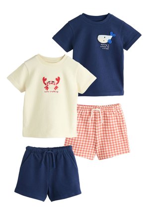 To sæt tøj til småbørn: mørkeblå haveskjorte med hval og matchende shorts, cremefarvet krabbeskjorte med røde ternede shorts. Begge toppe har havdyrdesigns.