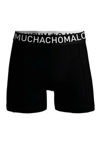 Melnas bokseršortus ar baltu "MUCHACHOMALO" logotipa jostas daļu, izgatavoti no elastīga auduma, kas nodrošina ciešu piegulumu un nav redzamu rakstu.