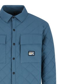 Gecoate blauwe jas met een kraag, twee borstzakken, zwarte knopen en een "PROTEST" patch met bergafbeeldingen en strepen.