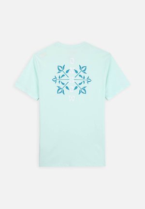 T-shirt vert menthe clair à manches courtes. Doté d'un design graphique bleu et blanc avec des éléments botaniques au dos.