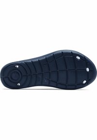 Suela de zapato de goma de un azul marino oscuro con patrones texturizados, surcos y múltiples acentos circulares de agarre. Presenta un logo central y bordes elevados.