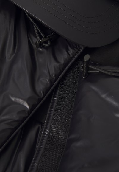 Giubbotto puffer nero con una texture lucida, dotato di chiusura con zip, cappuccio regolabile con cordino e dettagli in metallo neri.