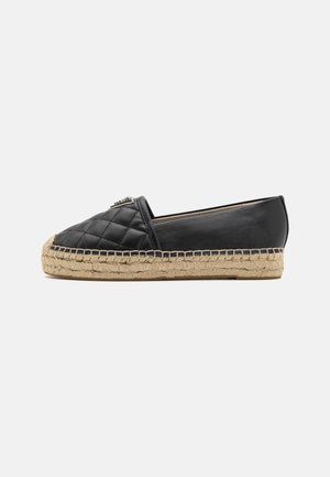 Espadrille noire en cuir matelassé à enfiler, semelle en corde de jute et petite plateforme, vue de côté sur fond uni.