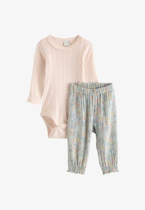 Lyserød ribbet babybodystocking med lange ærmer og trykknapper på skulderen, kombineret med lysegrå blomsterprintede elastiske bukser med flæsekant.