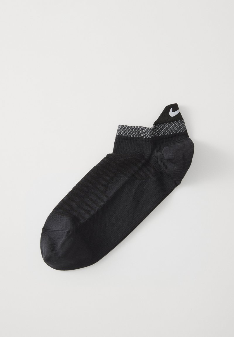 Čierna športová ponožka s textúrovanou podrážkou, tonálnym pruhovaním, ribovaným členkom a čiernym logom Nike na vrchu. Vyrobená z elastického materiálu.