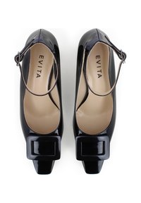 Scarpe con tacco alto nere e lucide, con punta quadrata e cinturino alla caviglia. L'interno è beige con il marchio "EVITA". Dettaglio con fibbia sulla punta.