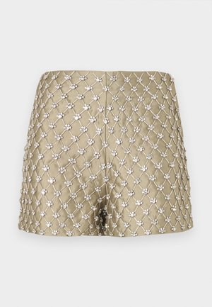 Shorts dorés présentant un motif en treillis diamant avec des ornements décoratifs de couleur argentée, un tissu lisse et une coupe ajustée.