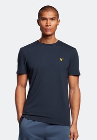 T-shirt a maniche corte blu navy in cotone, con colletto rotondo e un piccolo logo giallo sul petto.