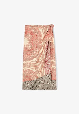 Spódnica kopertowa z czerwonymi i brązowymi skomplikowanymi wzorami kwiatowymi i kropkami na beżowej tkaninie, z wiązanym supełkiem w talii.