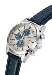 Orologio cronografo in tonalità argento con quadrante beige chiaro, sub-quadranti blu, cinturino in pelle di coccodrillo blu navy e dettagli testurizzati. Presenta una scala tachimetrica.
