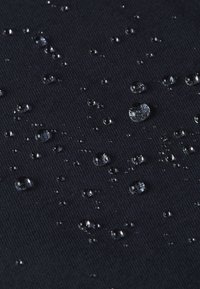 Zwarte textuurstof met zichtbare waterdruppels. Het oppervlak is glad met een lichte ribbeling, wat de waterbestendigheid benadrukt.