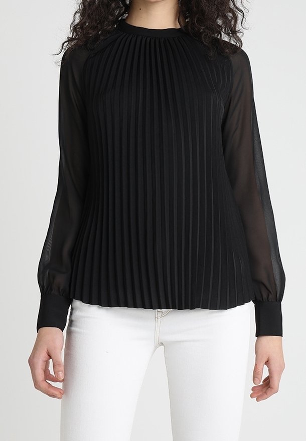 Blusa nera plissettata con maniche lunghe trasparenti, colletto rotondo e polsini elastici. Texture morbida, design fluido e materiale leggero.