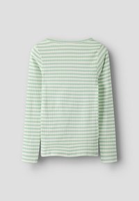 Bluzka z długim rękawem w jasnym zielonym kolorze z białymi poziomymi paskami. Miękka, prążkowana faktura i zaokrąglony dekolt. Z boku rozporki przy dolnym szwie.