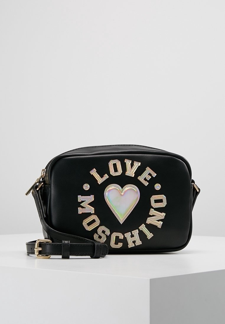 Mustat suorakulmion muotoiset olkalaukku, jossa on hohtava sydän ja "LOVE MOSCHINO" -kirjaimet ympyräkuviossa edessä.
