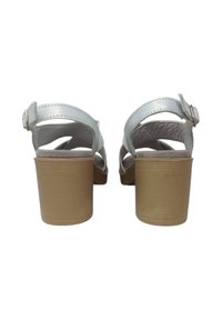 Sandali aperti bianchi in pelle, con una larga fascia, fibbia regolabile in argento e tacco spesso beige. Sottopiede testurizzato per il massimo comfort.