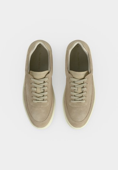 Μπεζ καστόρινες αθλητικές παπούτσια με κορδόνια, στρογγυλεμένες μύτες και εκρού καουτσούκ σόλες, σε λευκό φόντο από πάνω.