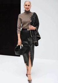 Brauner Rollkragenpullover, schwarze Leder-Bleistiftrock mit Oberschenkel-Schlitz, schwarze Tweedjacke, kleine schwarze Handtasche und braune High Heels.