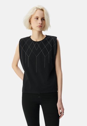 Top sans manches noir avec des épaules structurées, comportant une broderie géométrique argentée sur la poitrine et une coupe décontractée.