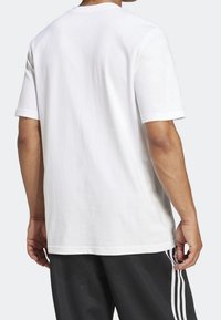 Hvid bomulds t-shirt med korte ærmer. Simpel design, almindelig pasform, ingen grafik. Bagview viser en glat tekstur og rund halsudskæring.