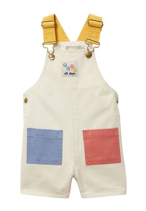 Salopette short crème pour tout-petit avec bretelles jaunes réglables, poches avant bleues et rouges, et un écusson "PLAY all days" sur la poitrine.