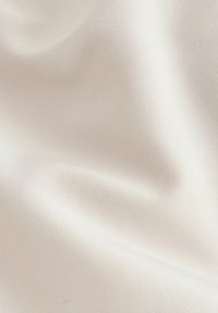 Tissu tissé ivoire, texture lisse avec un léger éclat. Présente des motifs subtils et un grain homogène, adapté à diverses applications textiles.
