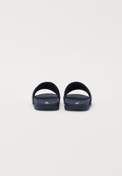Chanclas de goma navy con dos correas anchas, suelas planas y plantillas texturizadas para mayor agarre, que presentan un diseño simple y hardware mínimo.