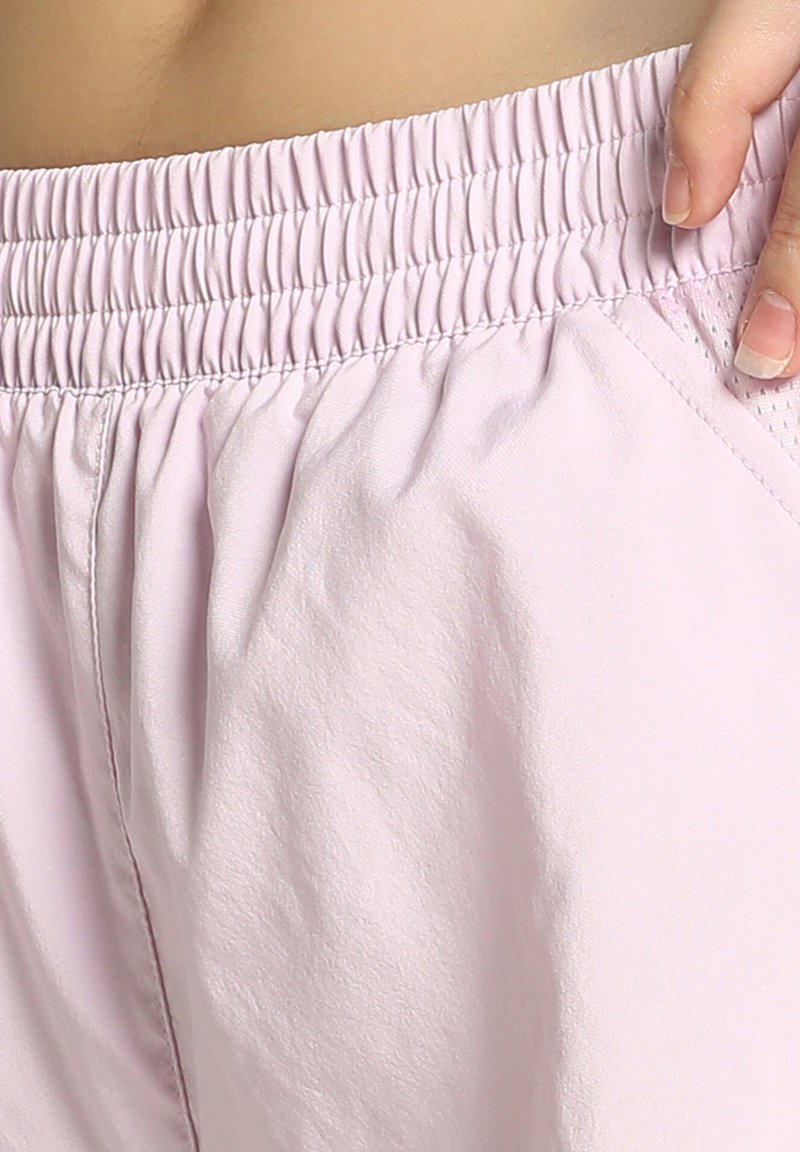 Lyserøde shorts med elastisk talje, glat tekstur og sidelommer, der viser samlet stof for en afslappet pasform.