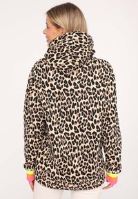 Leopard print hoodie in beige and black, featuring a high collar and colorful cuff accents. Made from soft fabric with a relaxed fit.