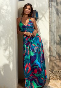 Maxikleid mit Neckholder-Ausschnitt, das ein farbenfrohes abstraktes Muster in Blau, Grün und Rot aufweist. Leichter Stoff mit einem fließenden Design.