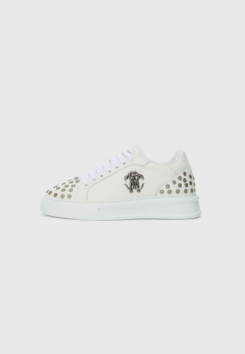 White leather sneaker featuring silver studs on the toe and heel, with a silver logo on the side and blue laces. Flat sole design.