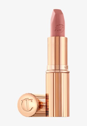 Rossetto rosa in una confezione esagonale, con finitura metallica color oro rosa, dettagli a coste e logo a forma di labbra sul tappo.