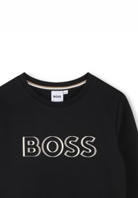 Black sweatshirt with a rounded neckline, featuring a large "BOSS" logo in white and gray, made of a smooth fabric.