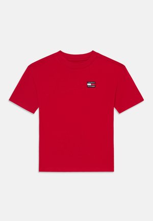 Rotes T-Shirt mit kurzen Ärmeln und Rundhalsausschnitt mit kleinem Tommy Hilfiger Logo-Patch auf der oberen linken Brust.