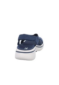 Sandali blu navy con tomaia in tessuto e suola in gomma bianca. Presentano cinturini regolabili in Velcro e una soletta imbottita per il comfort.