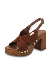 Sandale à talon bloc en daim marron avec des brides entrecroisées, plateforme en bois, embout rond et accents de rivets en métal sur le côté extérieur.