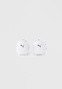 Hvite fotballsko med svarte Puma-logoer, med avrundede hæler og glatt, syntetisk materiale. Små aksentfarger på sidene.