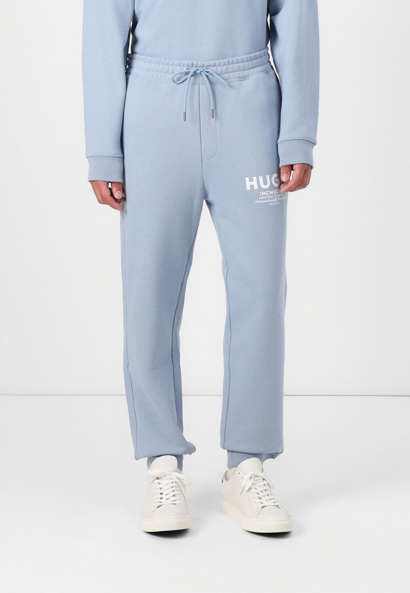 Lichtblauwe sweatpants van zachte stof. Voorzien van een elastische tailleband met trekkoord en een wit logo-accent op de linker dij.