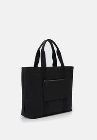 Zwarte draagtas gemaakt van duurzaam stof, met twee handvatten aan de bovenkant, een voorvak met ritssluiting en een gestructureerde rechthoekige vorm.