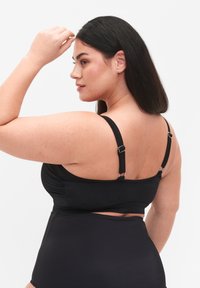 Sort to-delt badedragt med justerbare stropper, rynket detaljer og højtaljet bund med udskæring. Glat tekstur, minimalistisk design.