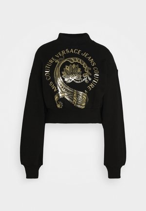 Felpa nera cropped con maniche lunghe, caratterizzata da un grande motivo paisley dorato e la scritta "Versace Jeans Couture" disposti in un motivo circolare.