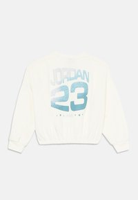 Kuttet hvit hettegenser med rund hals. Bakdelen har en blå og sølv "JORDAN 23" grafikk med et teksturert mønster, og ribbestrikket kant.