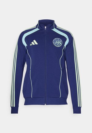 Navy athletic jacket with light green accents, zip front, high collar, and three-striped sleeves. Features a circular logo on the chest.