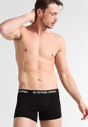 Schwarze Boxershorts aus elastischem Stoff mit einem kontrastierenden weißen "G-STAR RAW" Logo-Bund, enganliegendem Schnitt und glatter Textur.