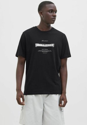 Black cotton T-shirt with short sleeves, featuring a silver graphic print "JACK & JONES" centered on the front. Circular neckline.