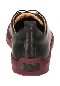 Schwarzer Ledersneaker mit bordeauxroter Gummisohle, geprägter Textur und runder Form. Verfügt über ein gepolstertes Innenleben und eine Zuglasche an der Ferse.