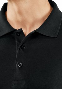 Schwarzes Poloshirt mit Kragen, ausgestattet mit drei schwarzen Knöpfen und einem strukturierten Stoff. Nahaufnahme des Kragens und der Knopfleiste.