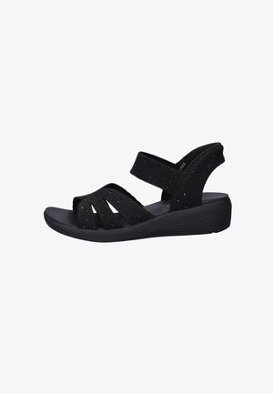 Black wedge sandal with textured fabric straps, adjustable ankle strap, and cushioned sole.