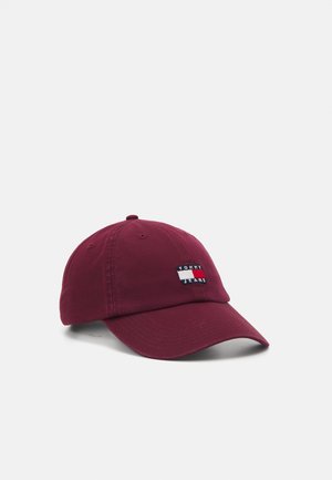 Bordowa czapka bejsbolowa z zakrzywionym daszkiem i naszywką z haftowanym logo Tommy Jeans na środku przedniej części.