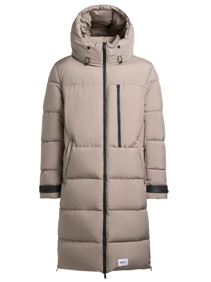 Dlhá nadýchaná béžová parka s vysokým golierom a kapucňou. Má predný zips, bočné vrecká a čierne akcenty na rukávoch.