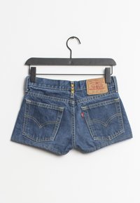 Shorts de mezclilla en un tono azul profundo, con una cremallera dorada, dos bolsillos traseros con costura curva y una etiqueta de la marca en la cintura.